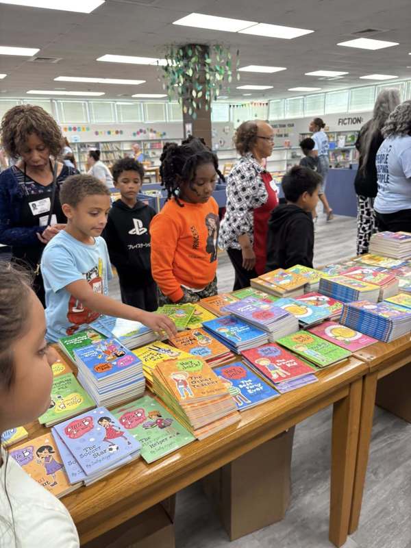 Third graders choosing books with the help of volunteers