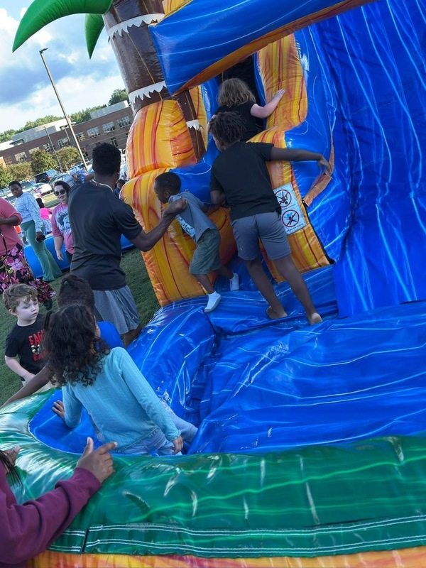 Students playing and bouncy house slide during  Spirit Night