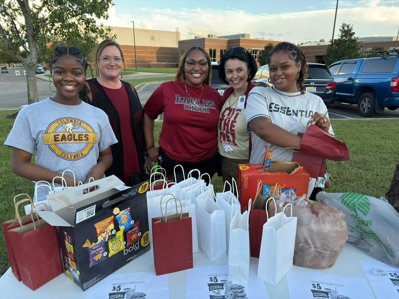 Five Teachers from Columbia standing in front of table with gifts on it
