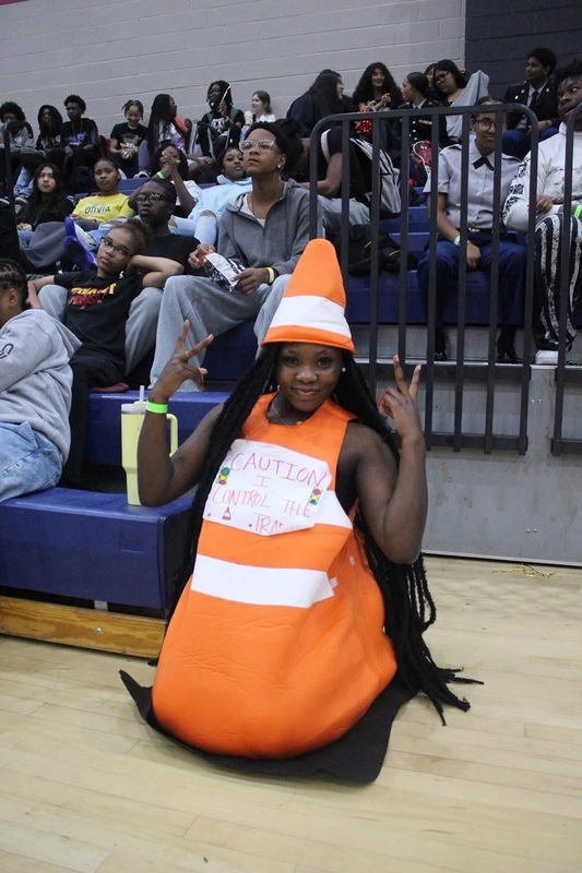 A girl in Candy Corn costume posing at Powderpuff game in gym during Spirit Week