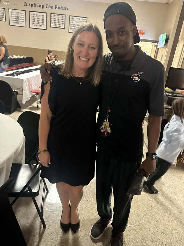 Mr. Battle and one of our community partners posing in the cafeteria.