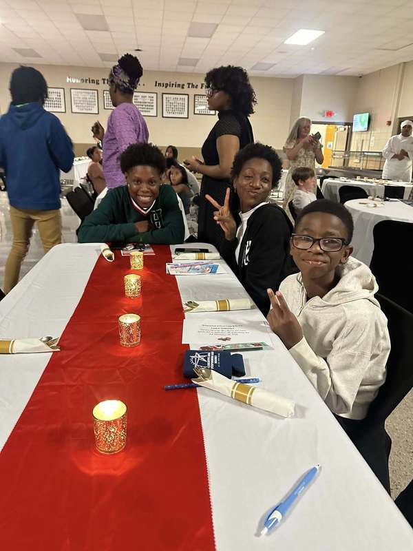 A family at the dinner table waiting to enjoy their meal.