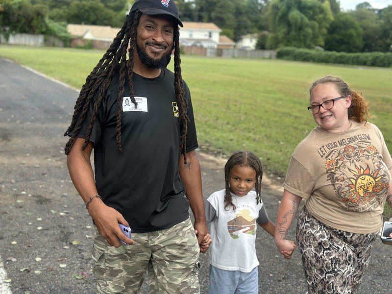 A photo of Ivan Martin-Young with his mom and dad enjoying the Fun Run.
