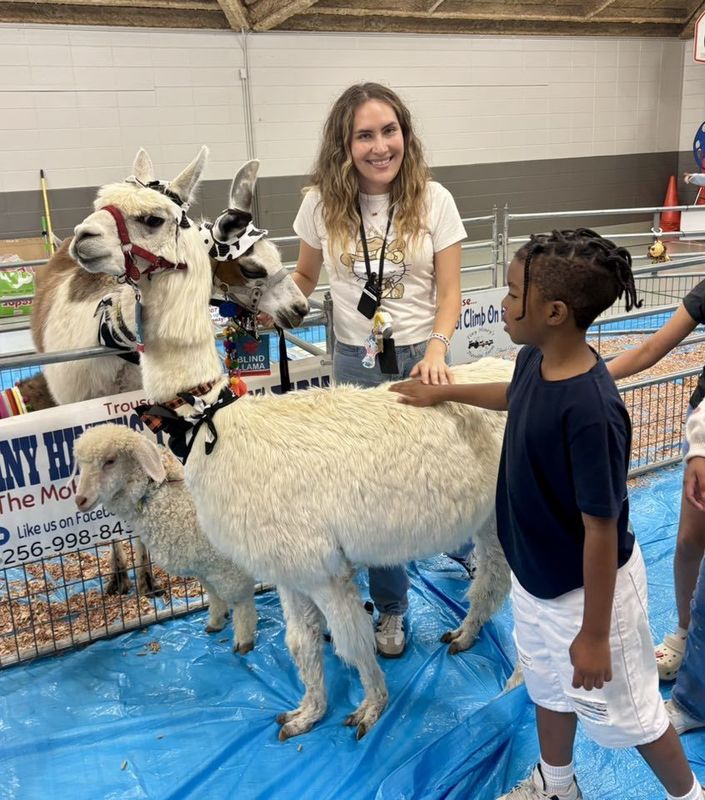 Ms. Aguilar holding Rascal while students petted him