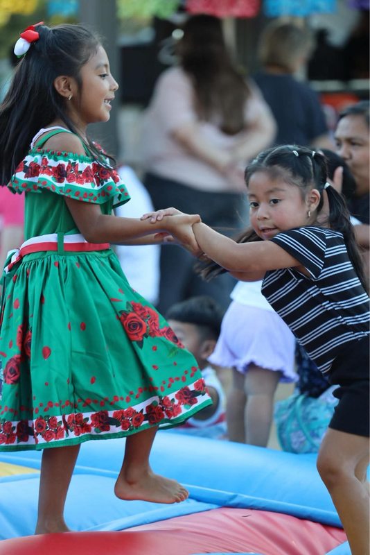 Sisters playing on the bounce pad during the celebration.