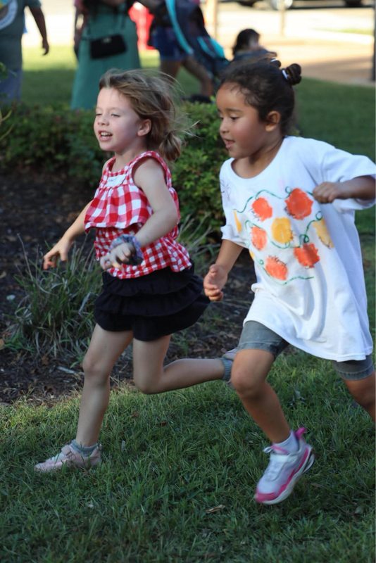 Kindergarteners running to the bounce pad at the celebration.