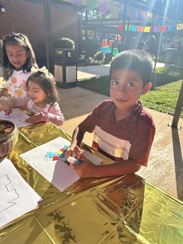Student making a pinata at the craft table.