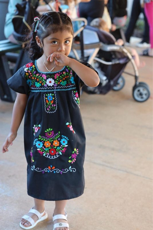 A little family member in a traditional Mexican dress.