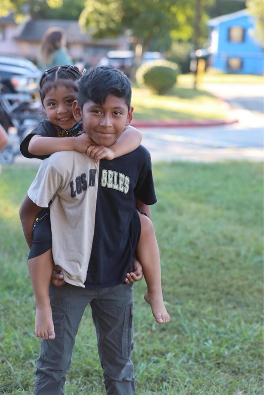 A student carrying his sister on his back and enjoying the event together.