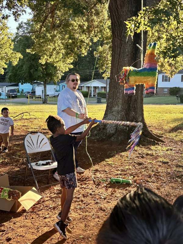 Student attempting to hit the alpaca pinata while Mr. Whetstone holds the rope.