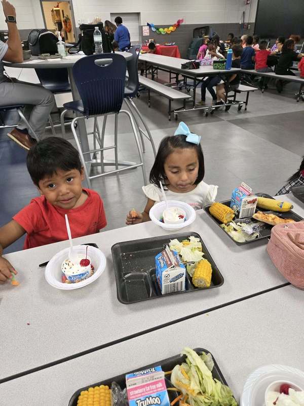 Preschoolers enjoying their ice cream sundaes at lunch.