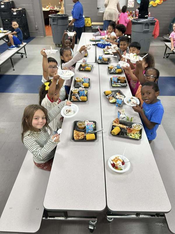 Kindergarteners showin off their sundaes with huge smiles!