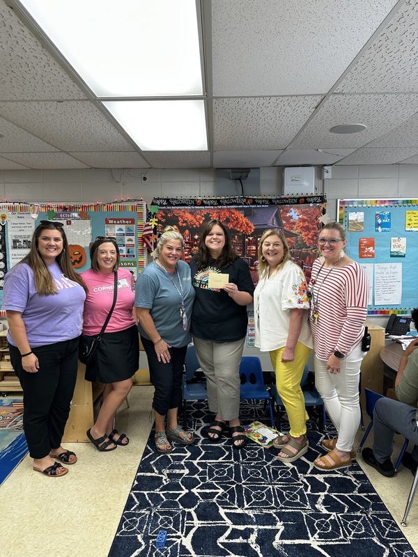 Ms. Noworyta accepting her Teacher of the Month award with staff members and community members.