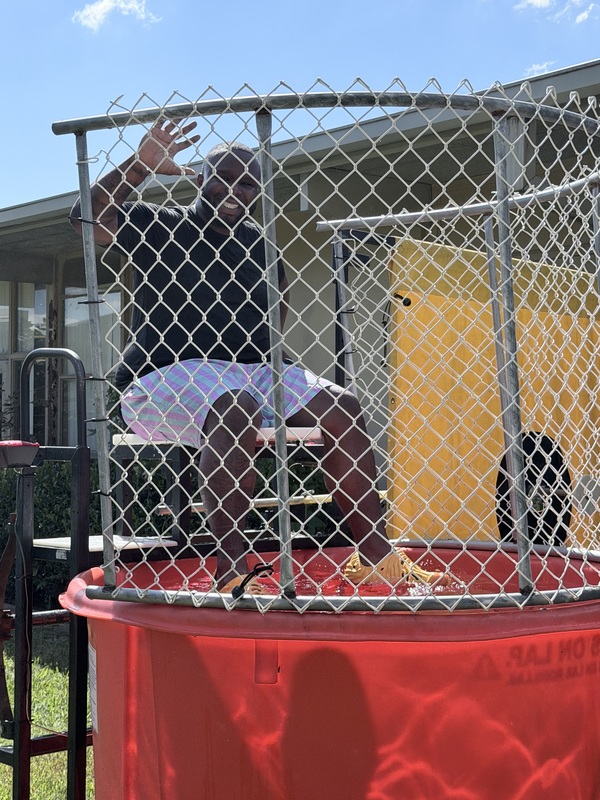 Mr. Thornton in the dunk tank, waving and wondering if anyone is going to sink him during the PBIS celebration.