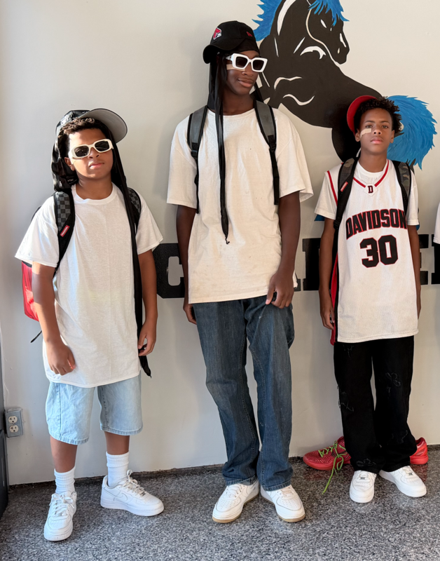 Students are pictured in the lobby with the school logo behind them while dressed as Soulja Boy, their favorite meme, during Spirit week.