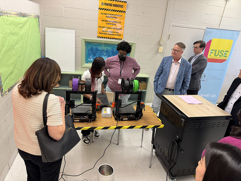 Mazda Foundation reps with student working on 3d printers