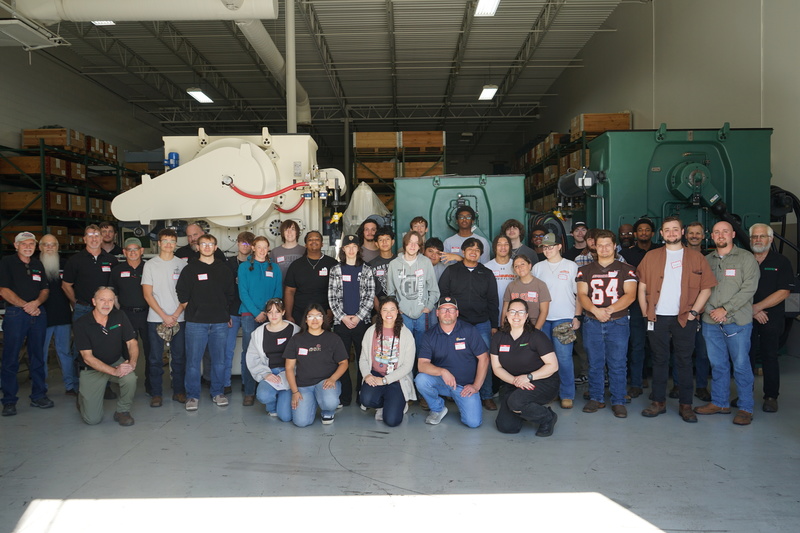 All of the Bruderer employees, precision machining, welding, and Huntsville City Schools staff pose in front of Bruderer Machines.