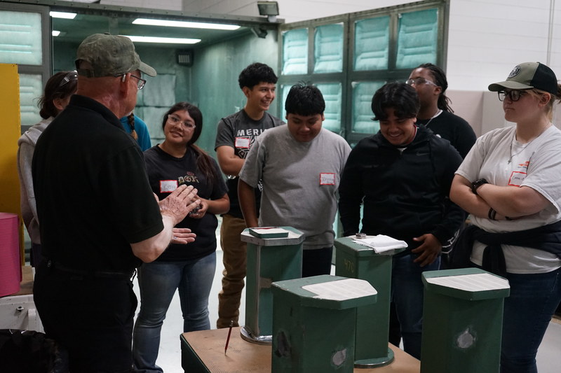 Bruderer employee explaining painting machines to the precision machining and welding students.