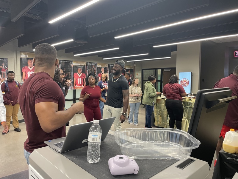 Football Coach, Booster Club President, Wrestling coach, teachers standing in line getting food 