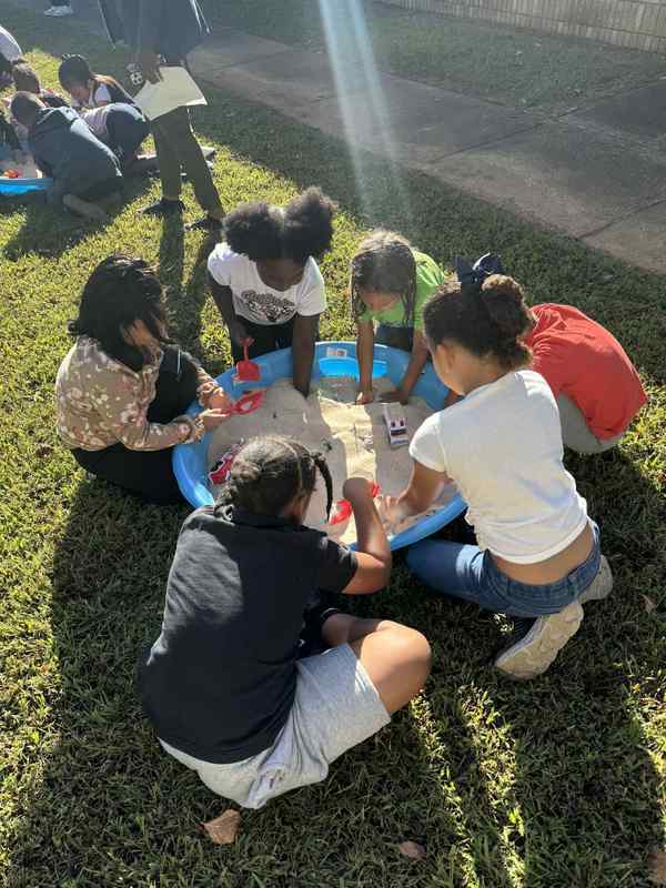 Students digging for treasure in the sand.
