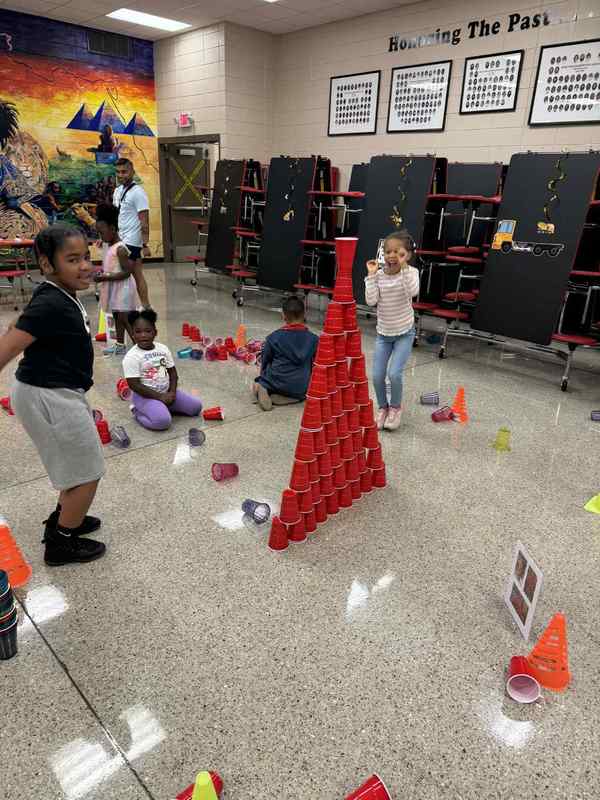 1st grade students building a pyramid with cups.