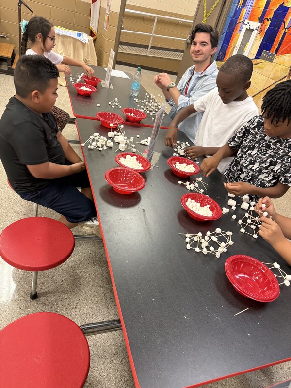 3rd grade students using marshmallows and toothpicks to build shapes.