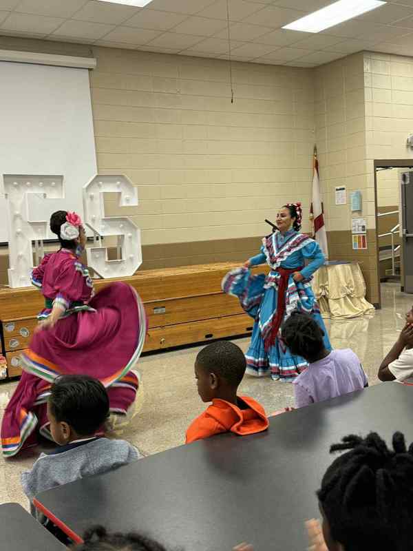 Latin Root dancers dancing in the cafeteria.