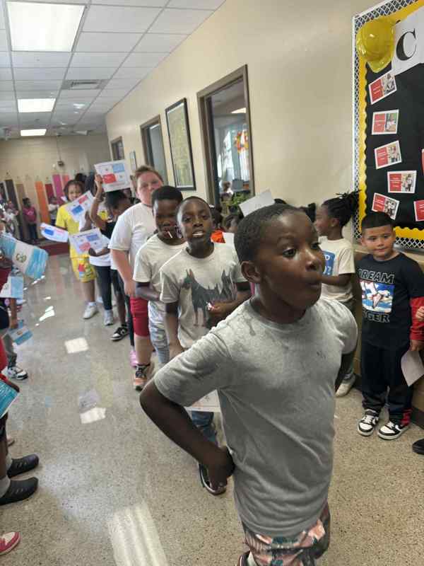 4th grade students walking in the parade representing Panama by holding up the Panama flag.