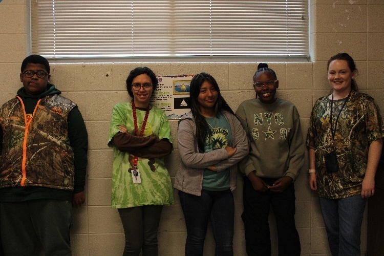 Three students and two teacher pose in their camo