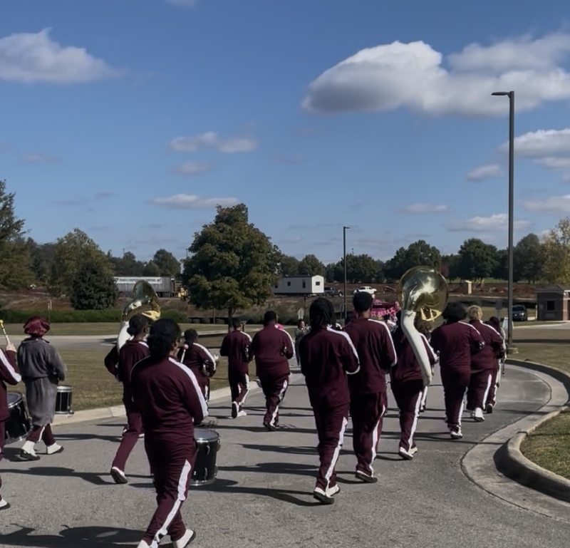 The Columbia band students walking around school dressed in burgundy and white uniforms playing instruments for breast cancer walk