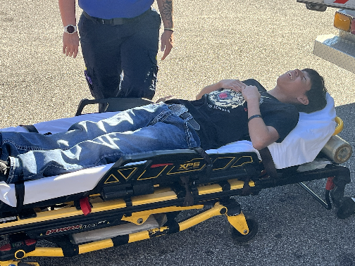 A student lies on a HEMSI stretcher pretending to be injured