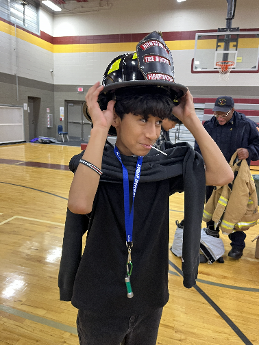 A student tries on a fireman's helmet