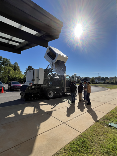 Students stand in front of a demonstration street sweeper built in Huntsville by Scharwe.