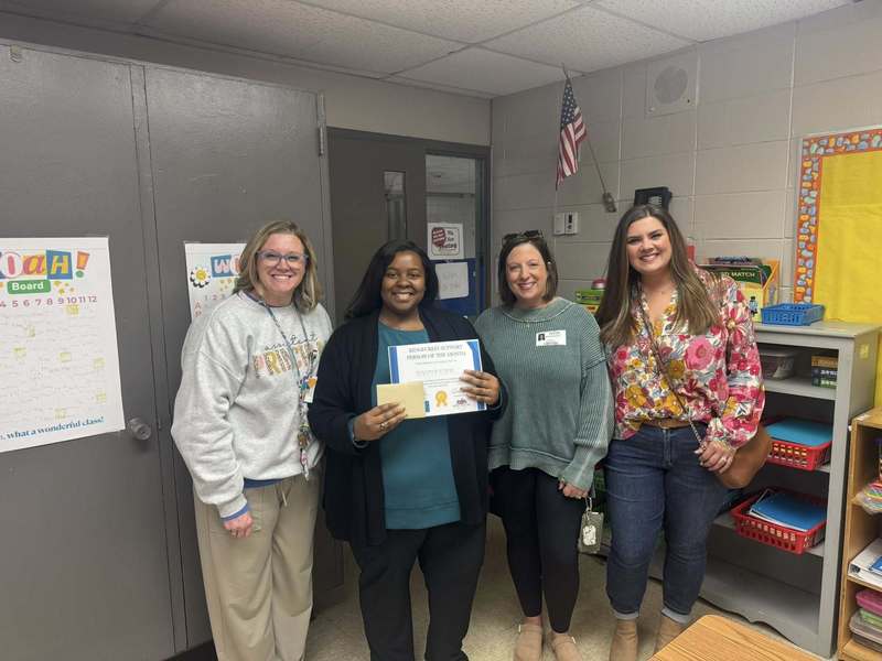 Ms. Ector receiving her award for Support Staff Member of the Month, surrounded by our Assistant Principal and community partners.