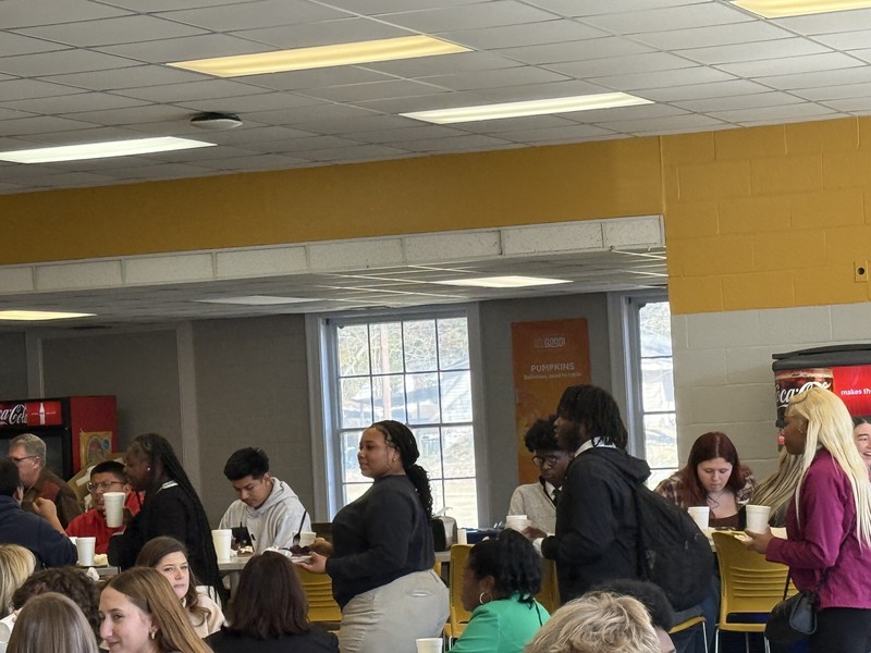 FBLA students sitting and standing in a classroom with yellow and white walls
