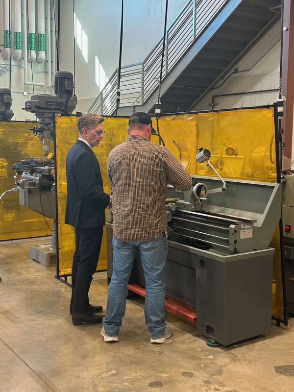 Dr. Mackey and Brian Wilkinson, precision machining instructor, in front of a manual lathe