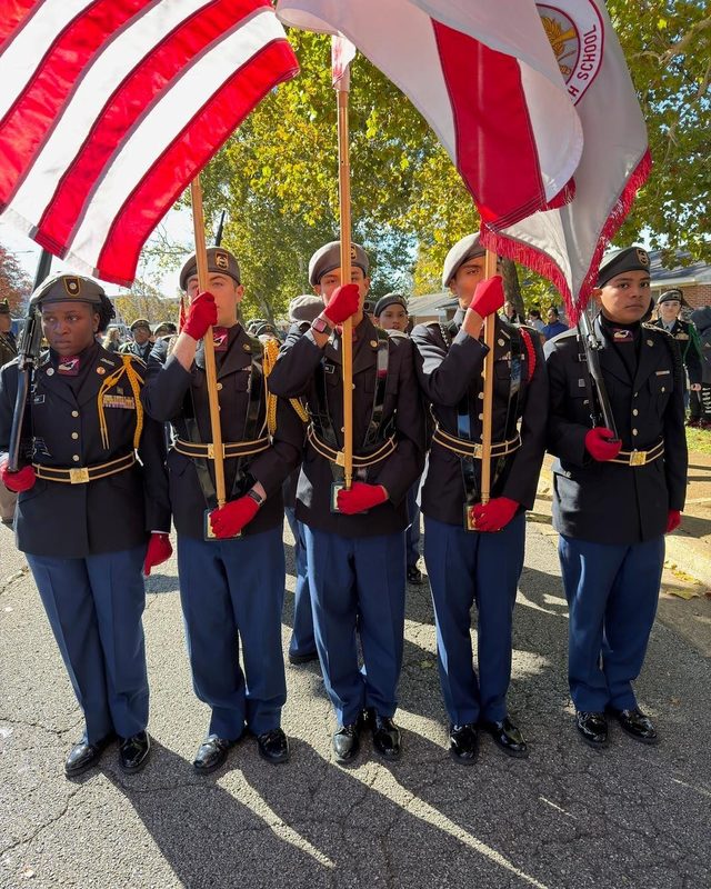 5 Columbia High Cadets in Class A uniform holding three red and white flags