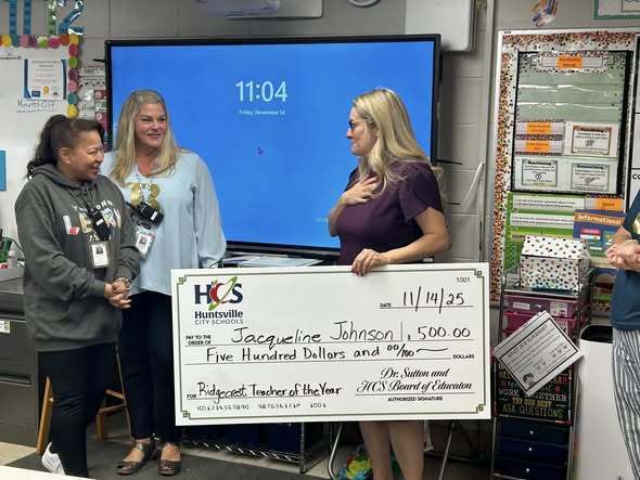 Johnson receiving her check from Obert and our principal, Lisa O'Bradovich.
