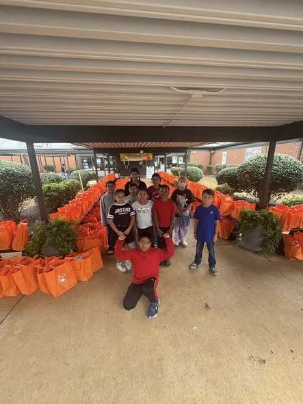 Student Council posing with the bags they helped unload at the front of the school.