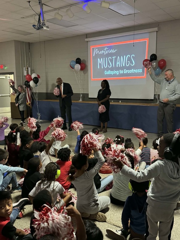 Principal Sutton, Superintendent Dr. Clarence Sutton, Deputy Superintendent Anthony Buckner, and Board Member Chaundra Jones speaking in front of the school.