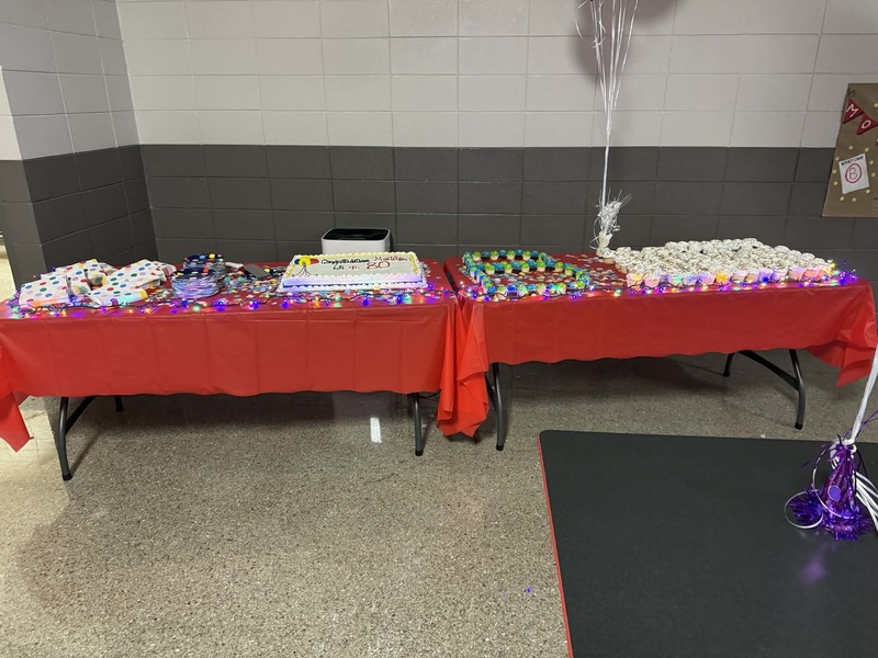 The celebration table with the cake and cupcakes.