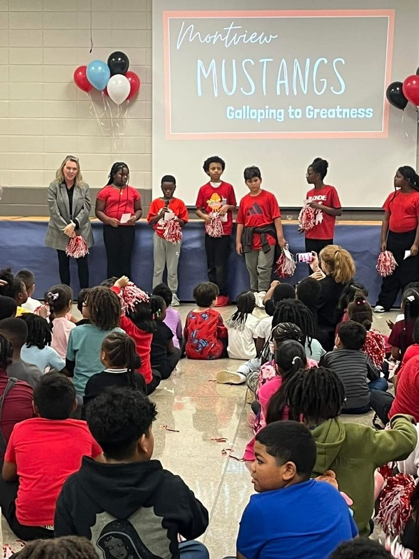 Principal Sutton and the SGA representatives are taking turns speaking to the students.