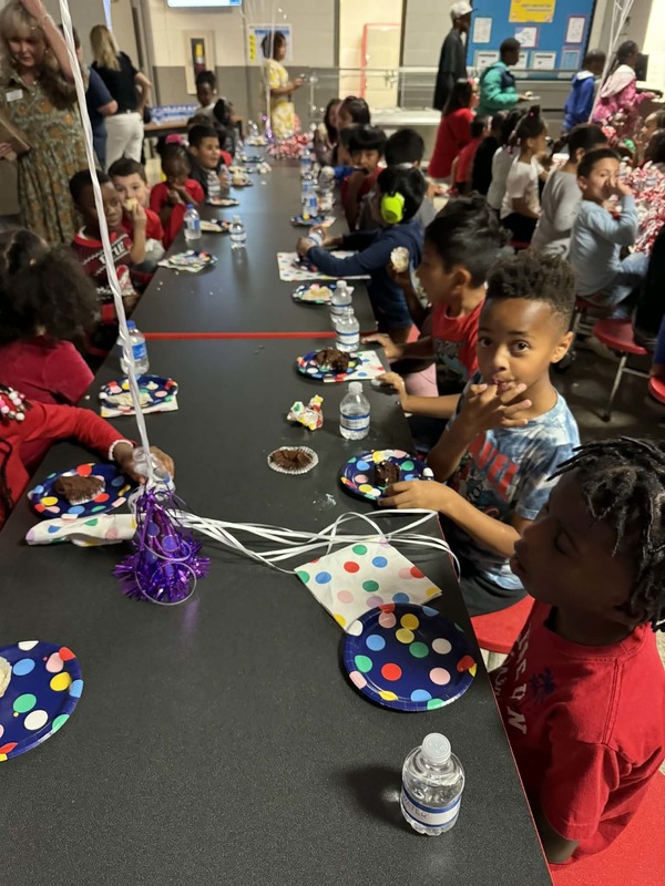 Students sitting at the table enjoying their cake.