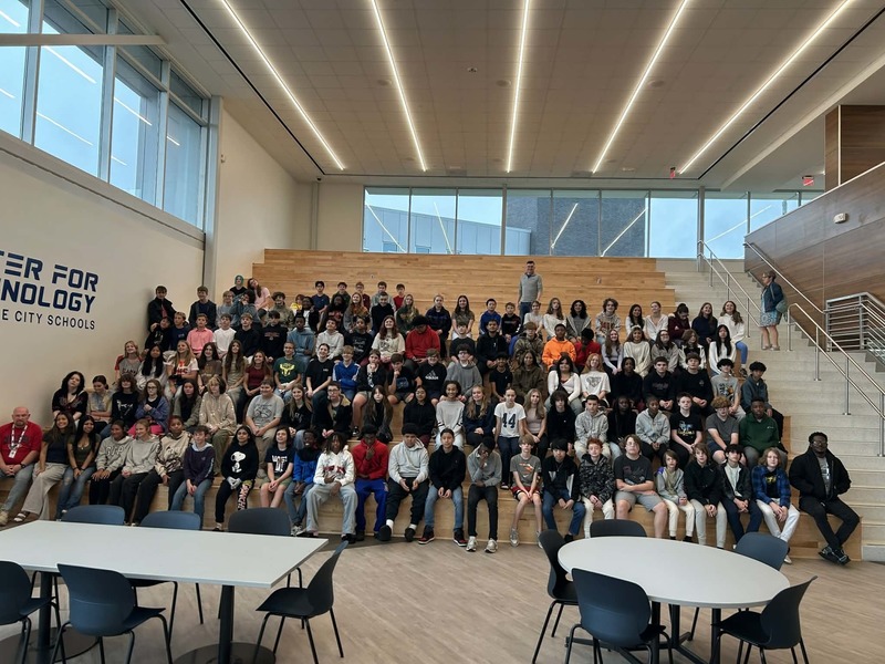 Middle School students sit on the stairs at HCT