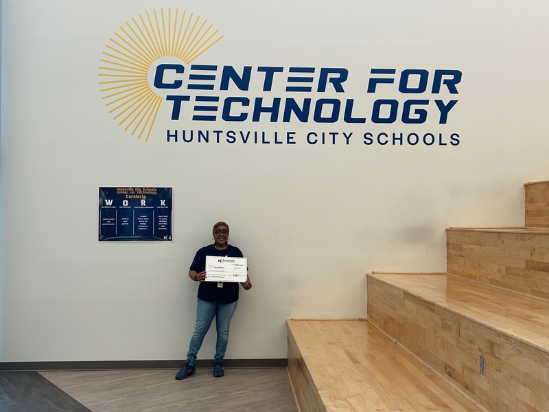 Ms. Tonya Robinson poses with her Support Person of the Year check in front of the Center for Technology logo