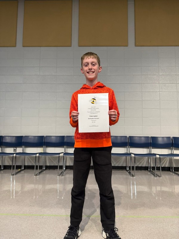 Winner of Spelling Bee, Crew L. holding his award.
