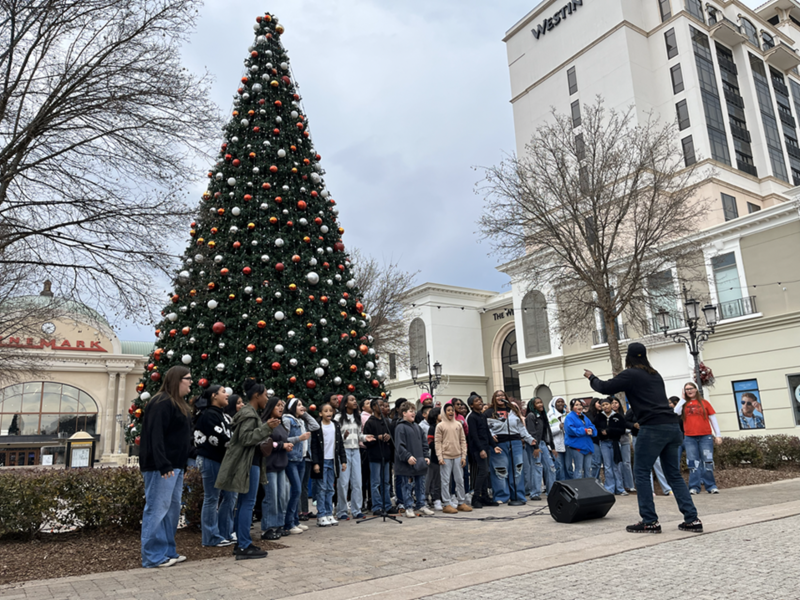 The MMS Choir singing in front of the giant Christmas tree in the  Bridge Street shopping center