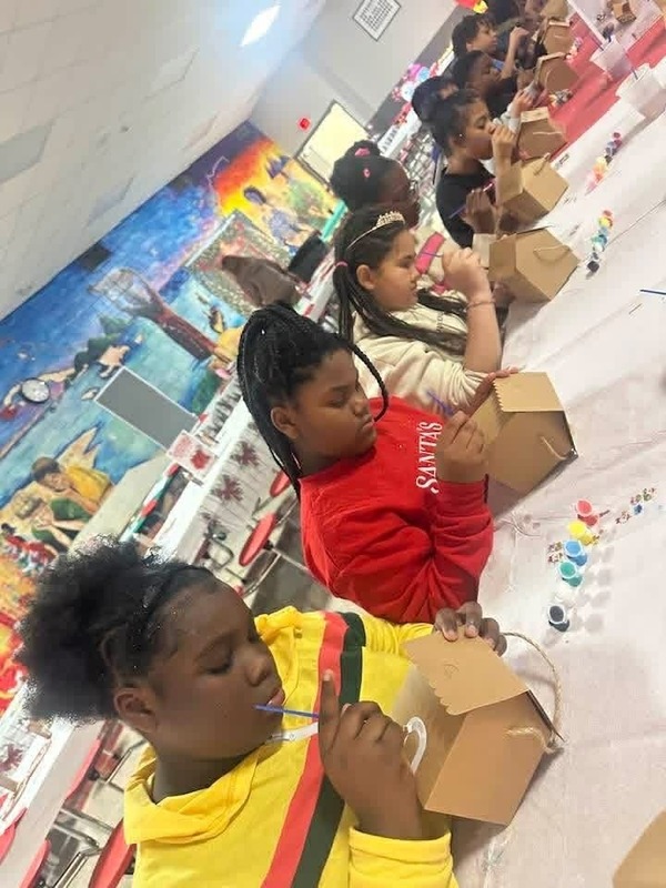 5th grade students concentrating on making their gingerbread houses.