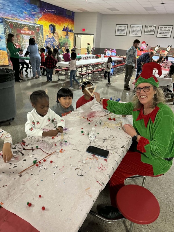 Ms. Boissel helping the first graders with their reindeer ornaments.