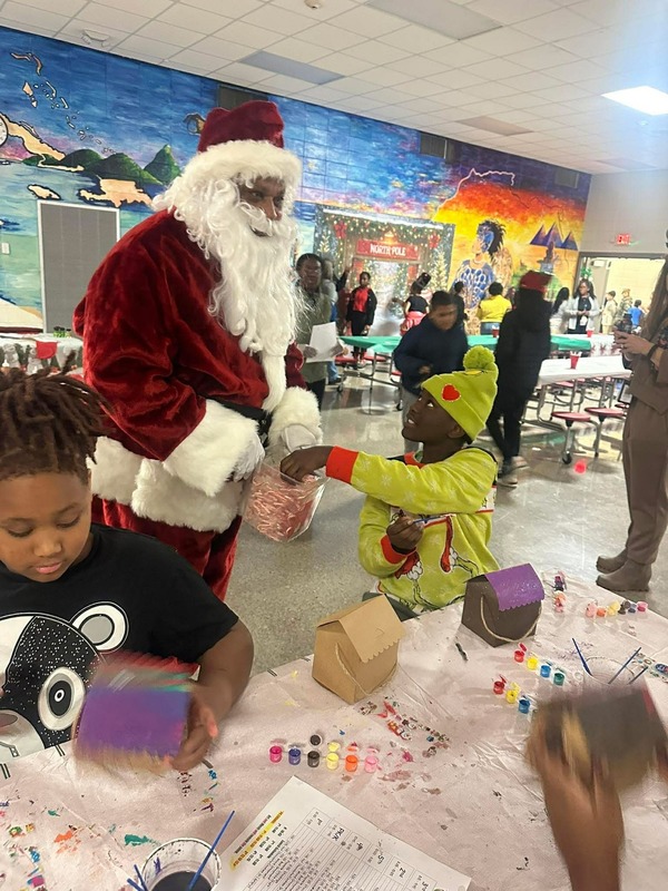 Santa came to visit on this special day!! He is in the cafeteria giving out candy canes to students. 